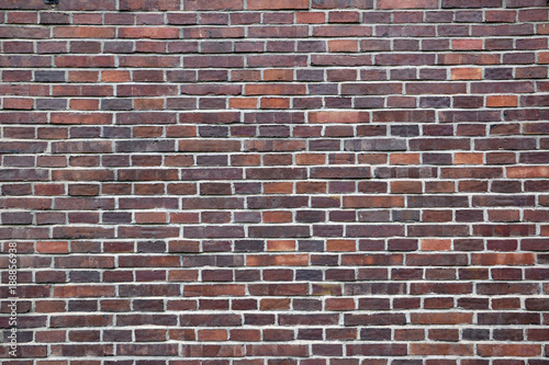 English bond brick wall, alternating stretching and heading courses, with the headers centred over the midpoint of the stretchers, and perpends in each alternate course aligned, dark and red bricks.