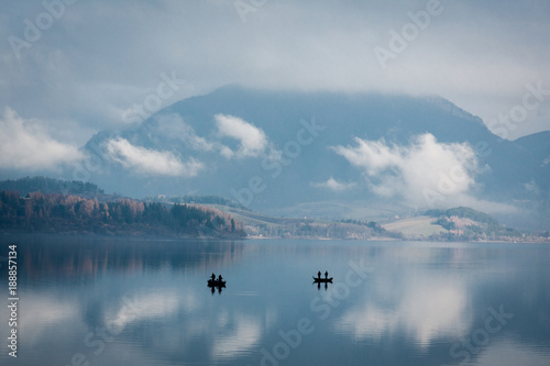Beautiful landscape with two fishermen boats on a lake photo