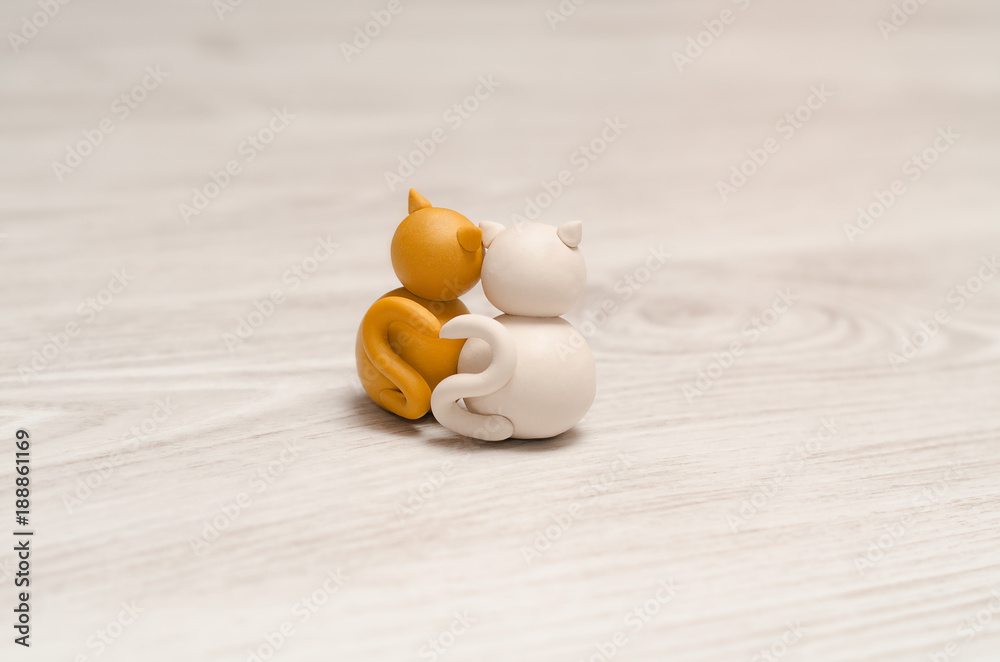 Two minimalistic animal figures in love. Lovely cat plasticine models having tails in heart shape. Happy Valentine's Day.