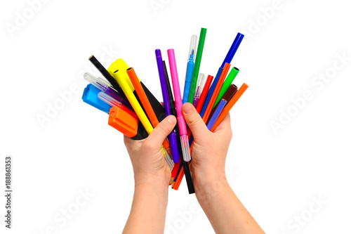 in children's hands colored pencils and markers, markers. Isolated on white background.