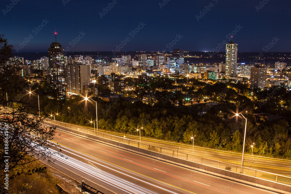 Downtown skyline and light trails from cars at night in Hamilton, Ontario
