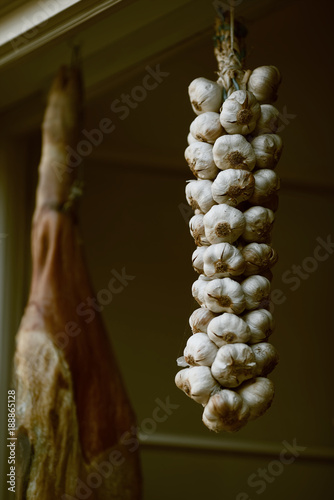 Traditionally homemade cured meat ,sausages and garlic, smoked, hanged in the market , hanging at window. Prosciutto meat with garlic and tomato

