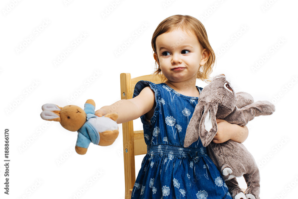 toddler girl sharing and offering a plush toy rabbit - obrazy, fototapety, plakaty 