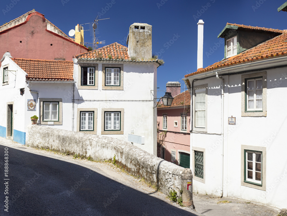 street in portugal city with white houses and blue sky