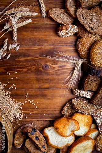 Assortment of baked bread on wooden table background