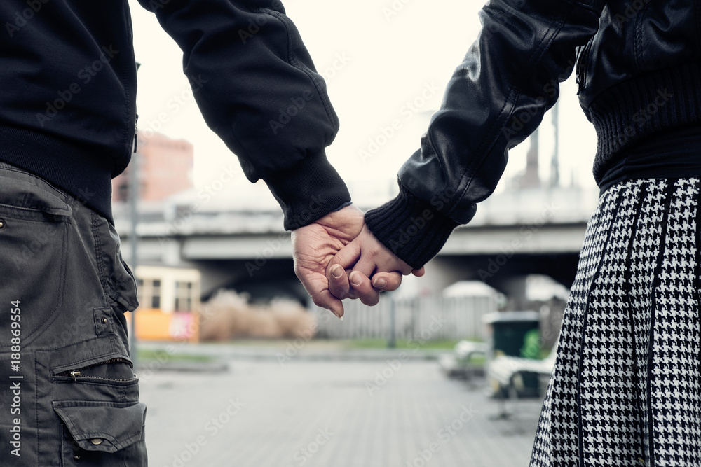 Naklejka premium Closeup of couple holding hands in the city