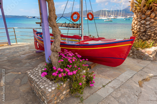 Red fishing boat with beautiful view of the Adamas sea port. Milos  Greece.