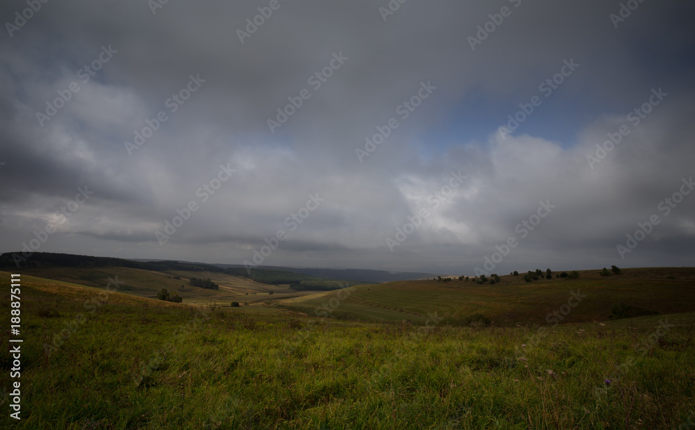  Storm clouds over the sloping meadows in the mountains.