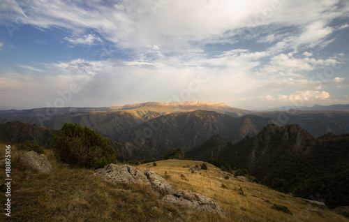 Fototapeta Naklejka Na Ścianę i Meble -   Autumn mountain canyon with cloudy sky and birch forest.
