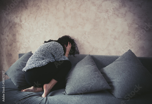 Woman in fetal position against harassment at home photo