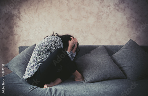Woman in fetal position against harassment at home photo