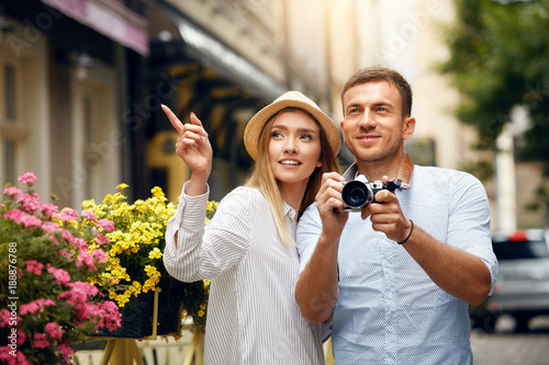 Tourist Couple Taking Photos On Camera On Street. photo