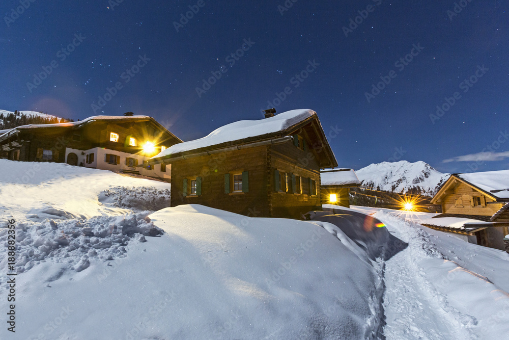 Hüttendorf in den Alpen im Winter bei Nacht