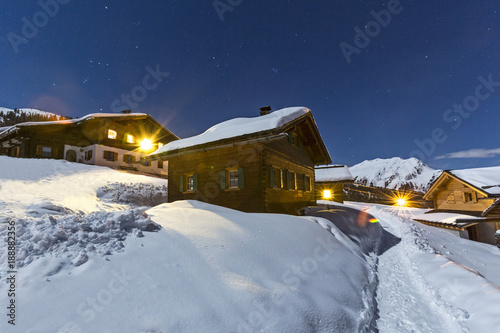 Hüttendorf in den Alpen im Winter bei Nacht