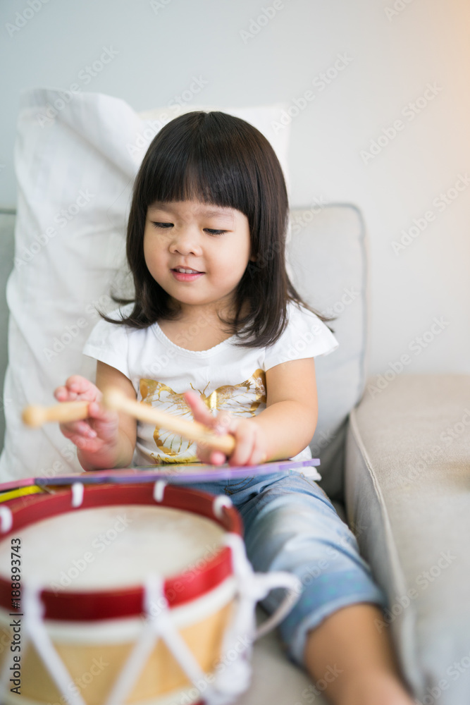 Little girl playing drum at home.Child development concept. Little girl playing drum at home.Child development concept.