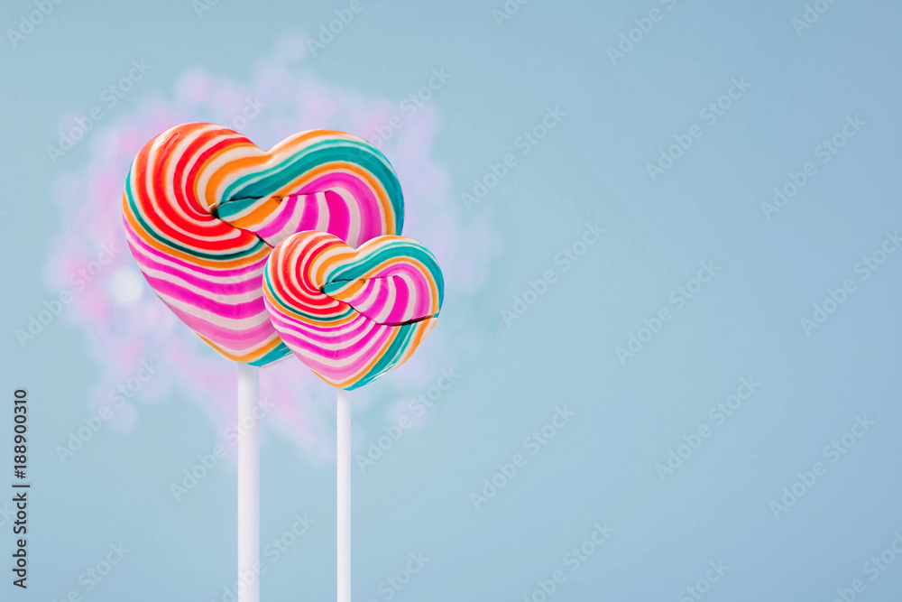 Love and Valentines Day Concept. Couple of Heart Sweet Lollipop Candy present over pastel blue background Love and Valentines Day Concept. Couple of Heart Sweet Lollipop Candy present over pastel blue background