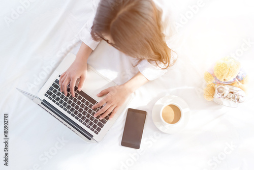 Portrait of a young business woman ,laptop,cup of coffee. Business concept a laptop drinking coffee with her computer on the bed