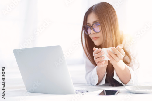 Portrait of a young business woman ,laptop,cup of coffee. Business concept a laptop drinking coffee with her computer on the bed