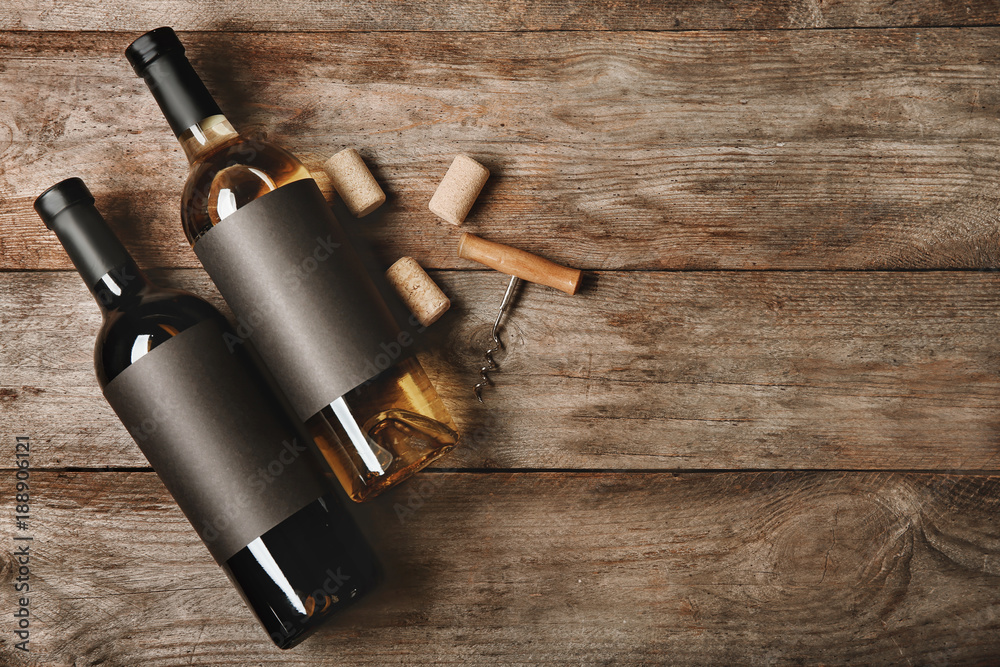Bottles with blank labels and corks on wooden background. Mock up for design