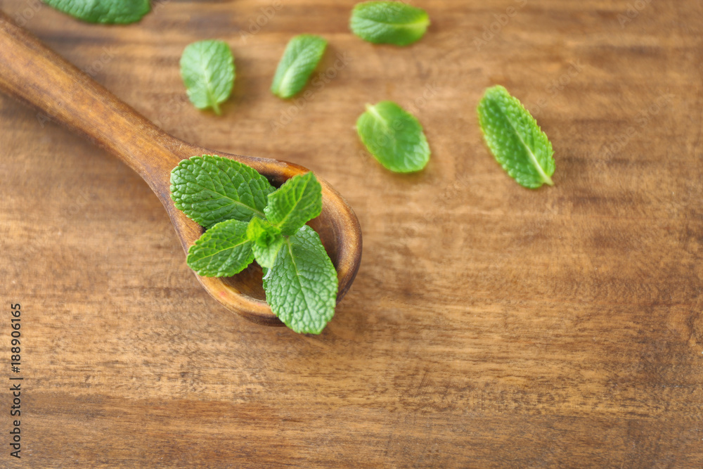 Fresh lemon balm and spoon on wooden background Fresh lemon balm and spoon on wooden background