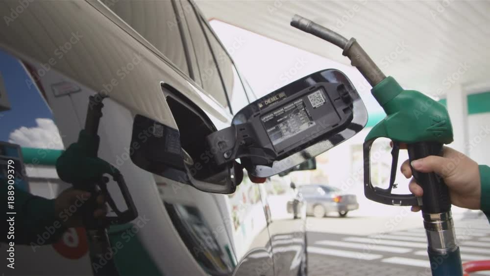 Worker Puts in and Takes Off Gun from Auto Gas Tank Closeup