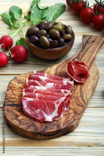 Fototapeta Naklejka Na Ścianę i Meble -  antipasto carne di porco salata su tagliere di legno sfondo tavolo di cucina
