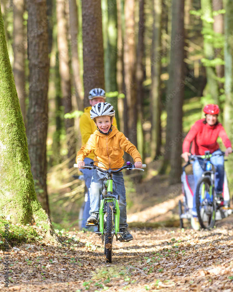 Obraz premium fröhlicher Junge beim Radeln im Wald