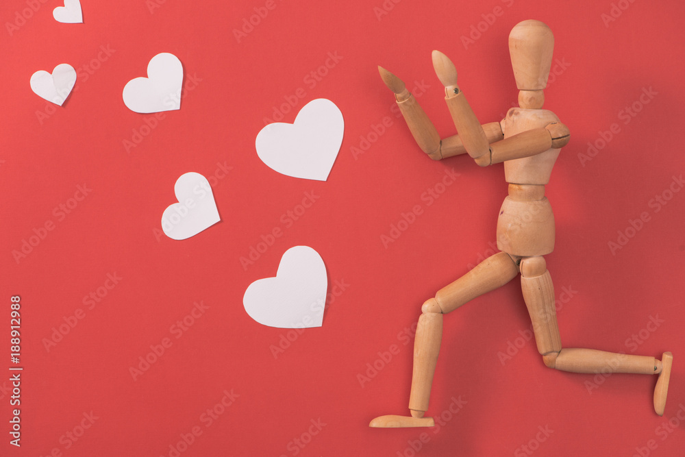 Wooden man figure running to catch red heart Wooden man figure running to catch red heart