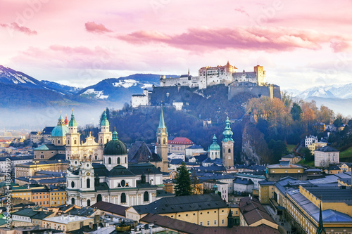 Salzburg, Austria. Sunset scenery in winter from above. View of the historic city of Salzburg with Salzburg Cathedral and famous Festung Hohensalzburg in Christmas time in winter, Salzburger Land.