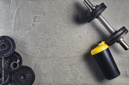 Fitness or bodybuilding concept background. Product photograph of old iron dumbbells on grey, conrete floor in the gym. Photograph taken from above, top view with lots of copy space photo