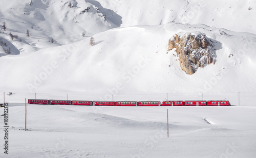 Bernina red train in snowy landscape photo