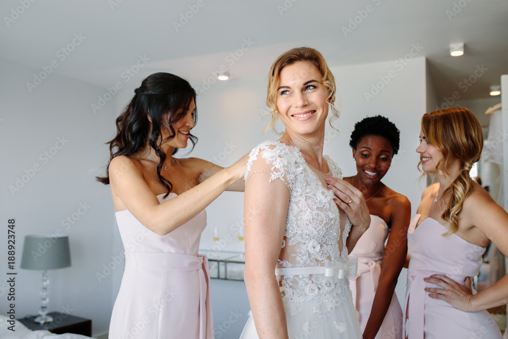 Friends dressing the bride for wedding