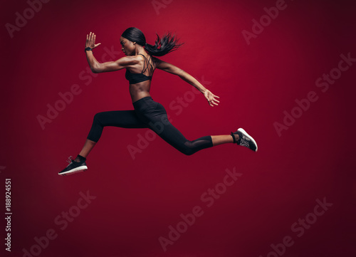 Female athlete running and jumping photo