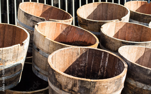 Old wooden half barrels. Ex wine casks having a second life to be used as decoration or as a flower planters. © Roman