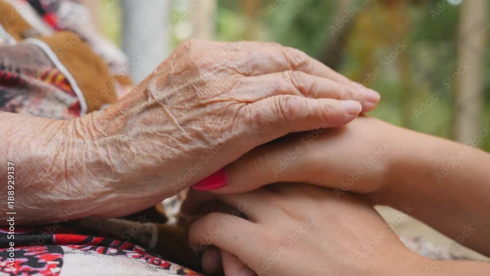 Old wrinkled and young female hands comforting and stroking each other ...