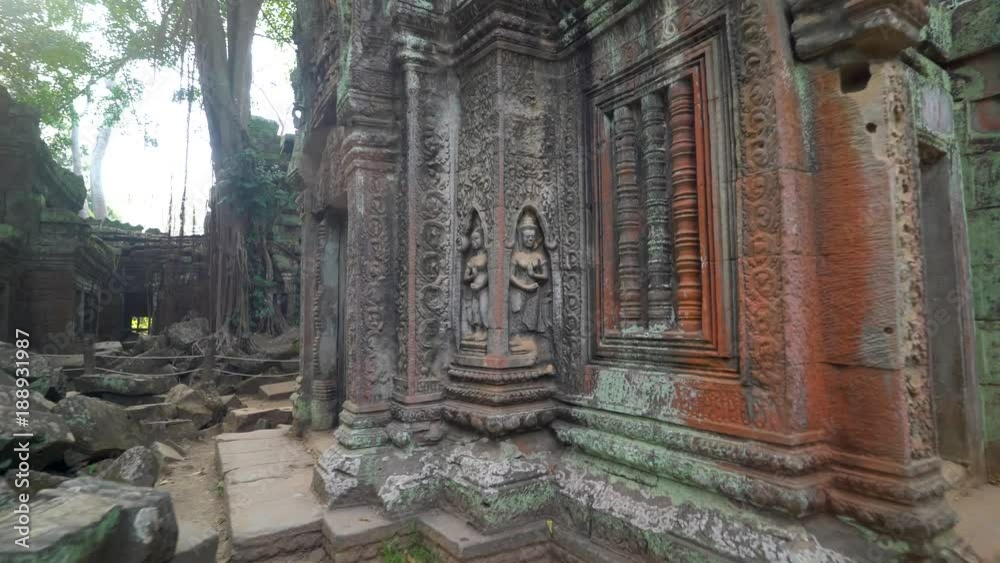 Steadicam gimbal push in to apsara dancers sculpted in bas relief on the Ta Nei temple complex.