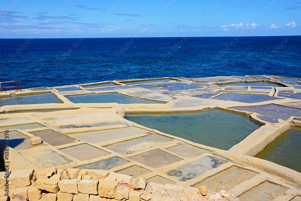 Salt pans along the waterfront with views out to sea, Marsalforn, Gozo, Malta.