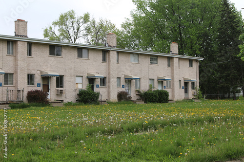Photography Low income housing with uncut grass and weeds