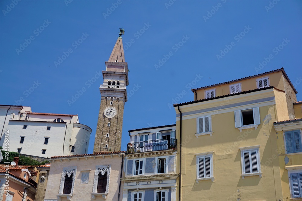 Pastel coloured houses and bell tower of Piran
