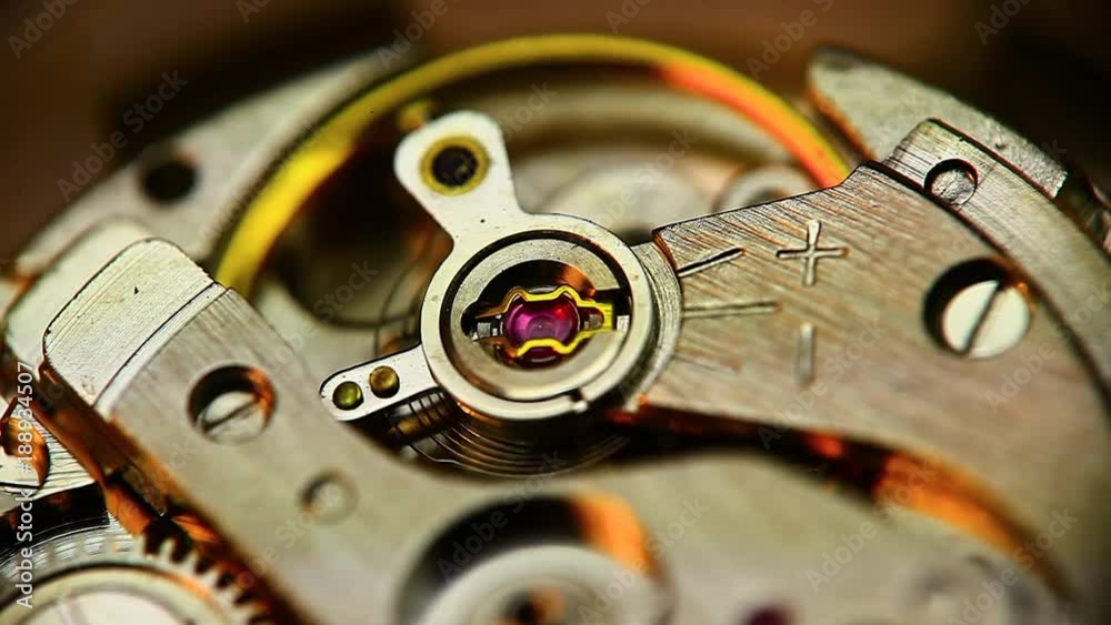 Close up shot of a balance wheel inside a wrist watch Close up shot of a balance wheel inside a wrist watch
