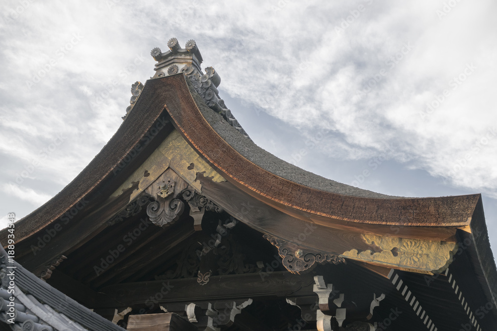 Detail of traditional Japanese wooden house in park area with roof decoration elements in September in Kyoto, Japan Detail of traditional Japanese wooden house in park area with roof decoration elements in September in Kyoto, Japan