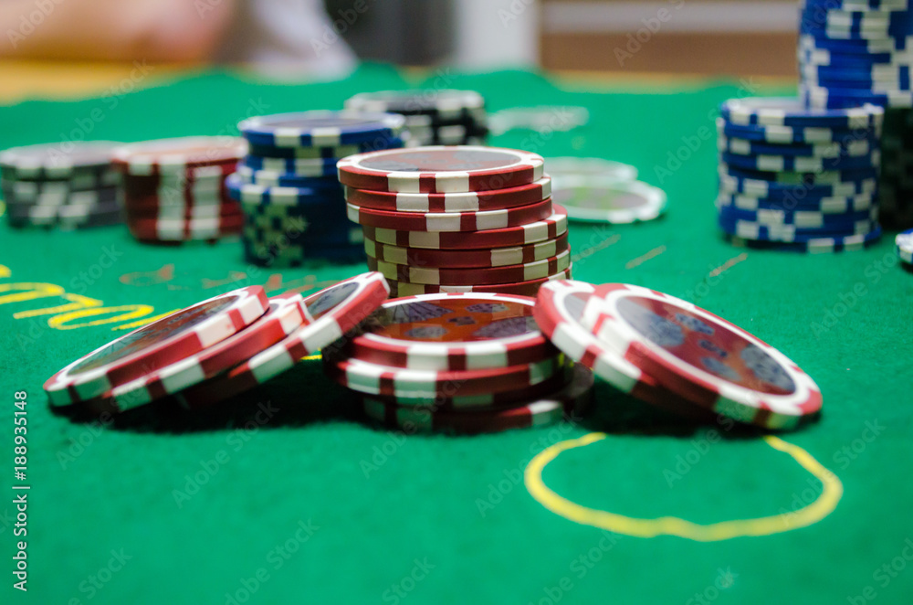 poker chips with playing cards on a green table poker chips with playing cards on a green table