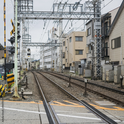 Detail of local railway station with contact lines, traffic signals and rails in Kyoto, Japan.