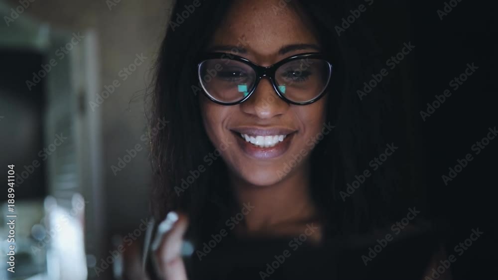 Woman in eyeglasses using smartphone touchscreen at dark home corridor Woman in eyeglasses using smartphone touchscreen at dark home corridor