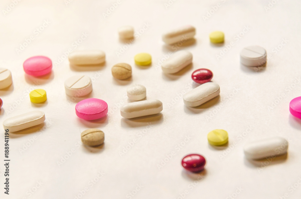 Close-up of the pills on the white background, The drug and capsule pills on the floor, Pile of the drug and pills on the white background. Close-up of the pills on the white background, The drug and capsule pills on the floor, Pile of the drug and pills on the white background.