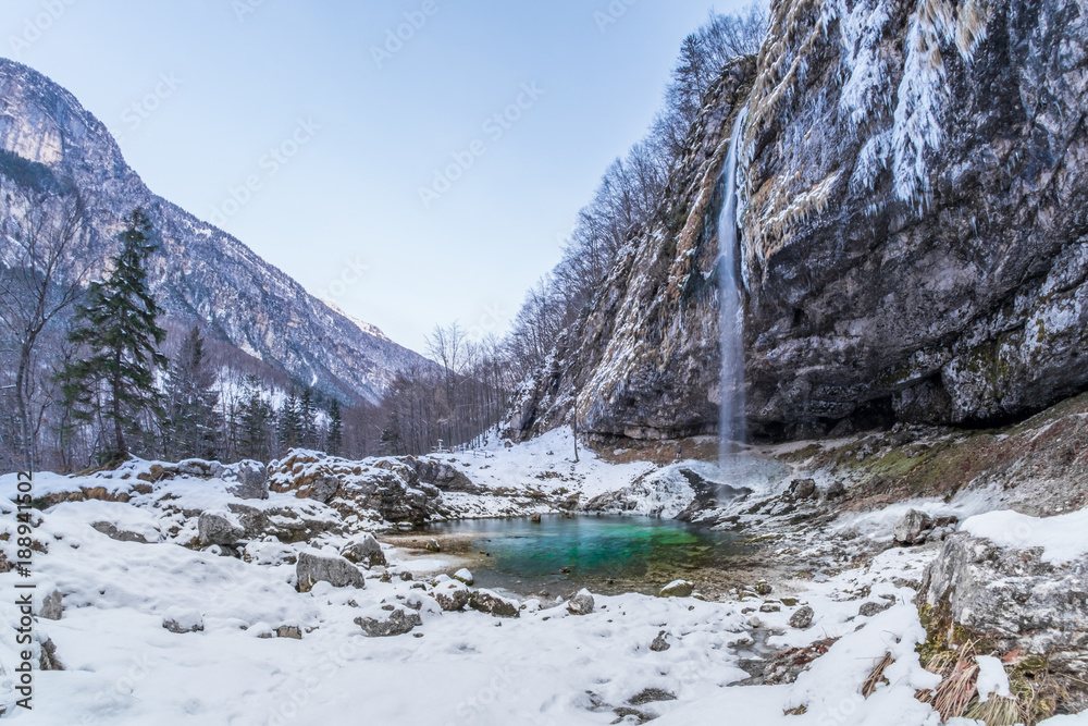 Solitude waterfall Goriuda flows in turquoise lake in Italian alps