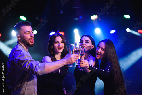 Young attractive women and man celebrating a party, drinking champagne and dancing. Birthday party.