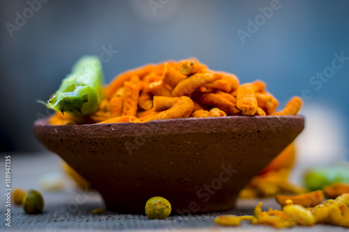 Close up of Indian appetizer, tikha gathiya, bhavnagri gathiya, served as a snacks with green chilly and salad with a cup of tea, cutting chai. photo