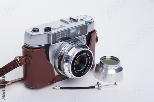 Alte Fotokamera in Ledertasche mit Filter und Drahtauslöser vor weißem Hintergrund