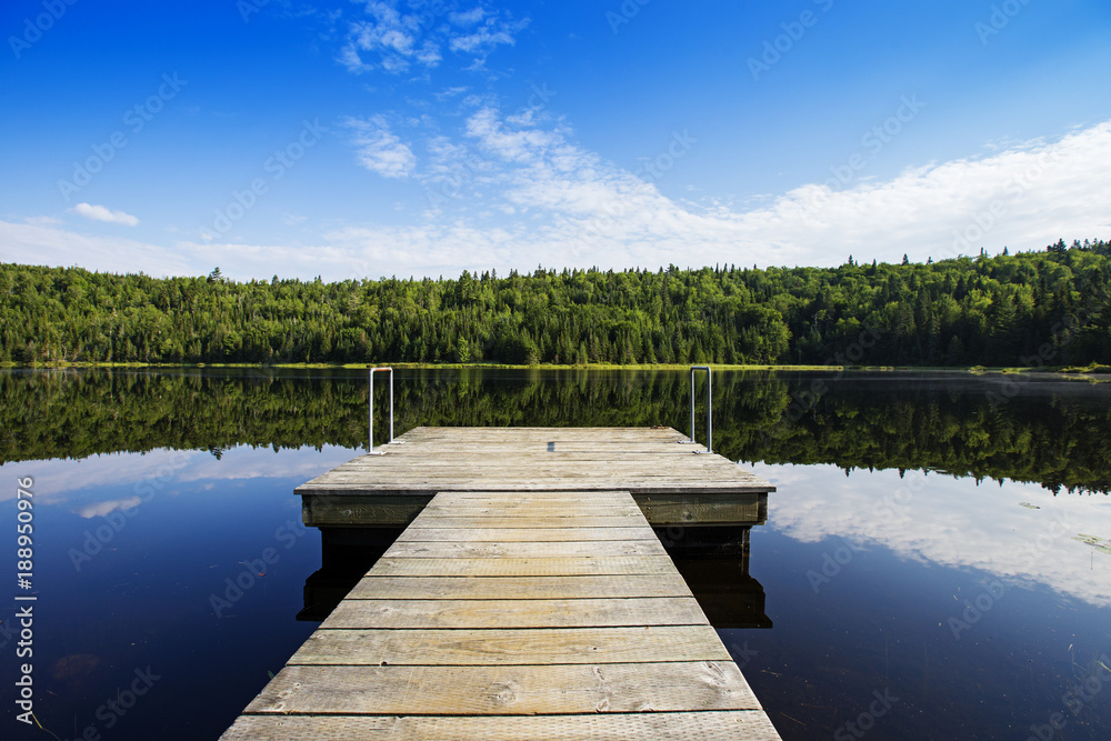 Empty footbridge over a tranquil lake in Mauricie national park, Canada